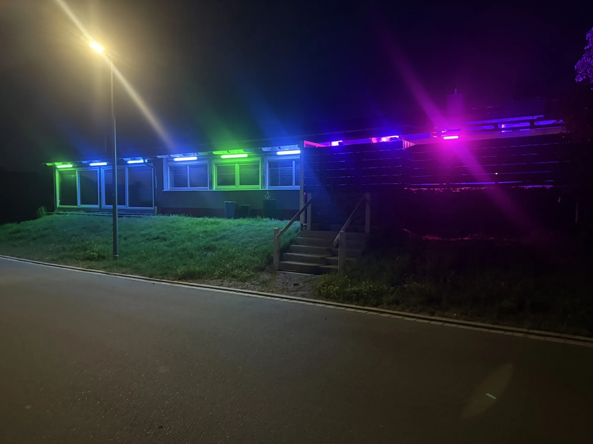 Außenansicht bei Nacht mit farbiger Beleuchtung